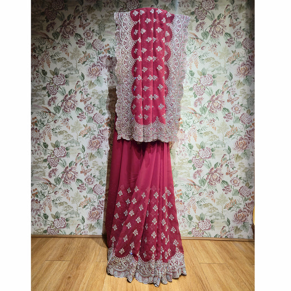 Rani pink georgette saree with silver stones, motif work, and embroidered border