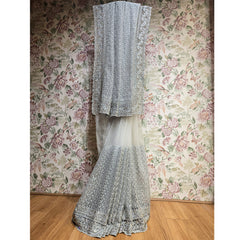 Ivory net saree with scalloped silver stone border, draped vertically