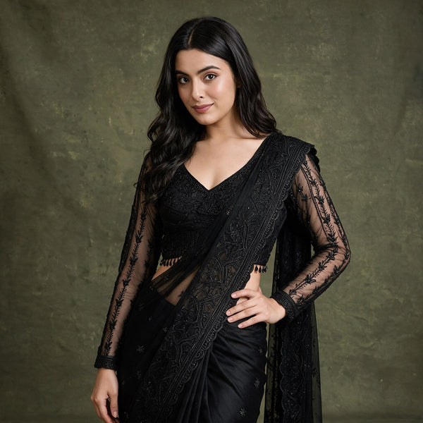 Black net saree with embroidered border and long sheer sleeves, V-neck stitched blouse