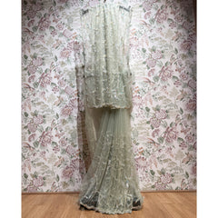 Sage green net saree with sequin lattice and cut dana, layered border drape.