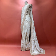 Ivory honeycomb crepe silk saree with gold handwork border on mannequin