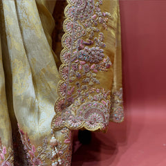 Close-up of pink and mauve resham flower border with zari, stones and tassels on gold Kanjivaram
