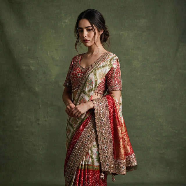 Close-up of the red gharchola saree draped over the shoulder, showing the gold handwork border, red bandhani pallu woven with gold and the red handwork blouse