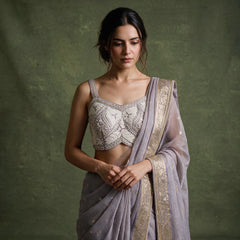 Close-up of the lilac viscose linen saree draped over the shoulder, showing the gold check, zari border and the ivory sleeveless blouse with leaf and floral bead handwork