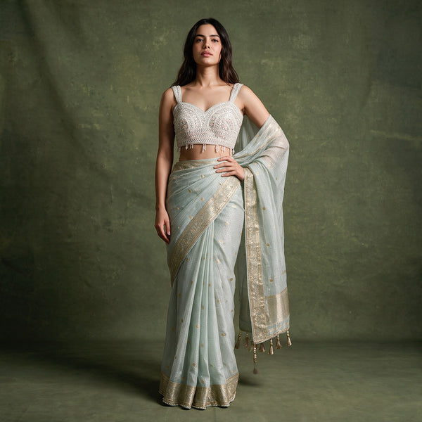 Mint green saree with zari border and sleeveless embroidered blouse