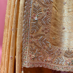 Close-up of beaded leaf-and-vine handwork border and pearl tassels on gold viscose silk