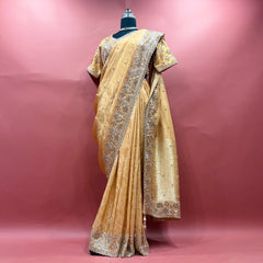Gold viscose silk saree with handwork border and ready blouse on mannequin