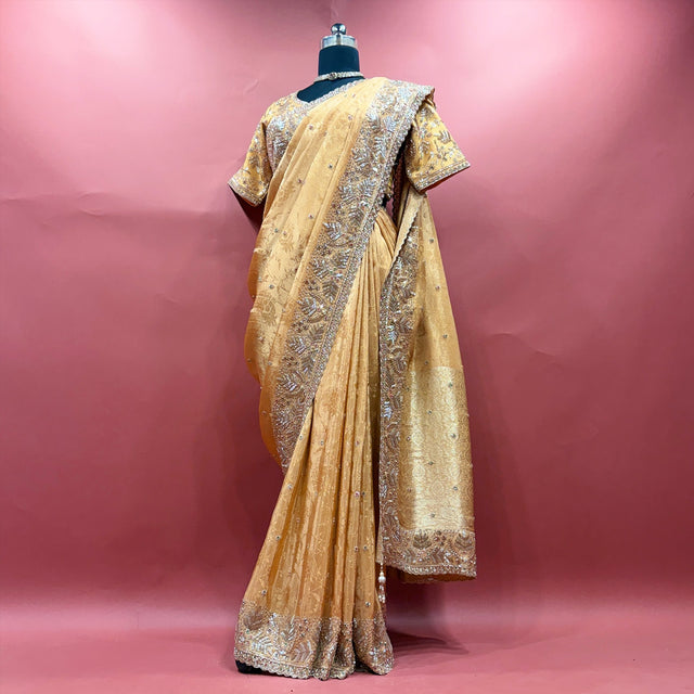 Gold viscose silk saree with handwork border and ready blouse on mannequin