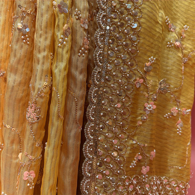 Close-up of pearl, bead and sequin border and pink sequin flower jaal work on yellow organza