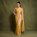 Yellow ombre viscose organza saree with scalloped handwork border and gold blouse, worn