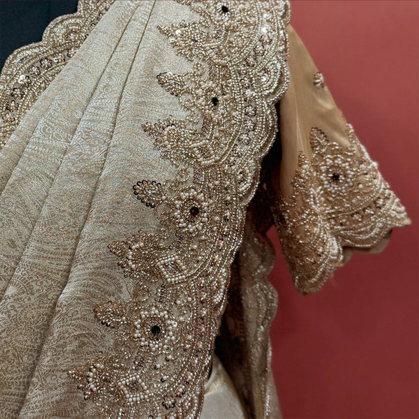Close-up of pearl bead and cutdana flower border and beaded sleeve cuff on champagne tissue