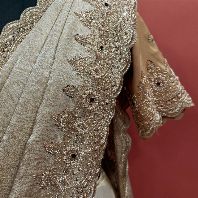 Close-up of pearl bead and cutdana flower border and beaded sleeve cuff on champagne tissue