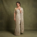 Champagne viscose tissue Kanjivaram saree with scalloped beads and cutdana border and stitched blouse, worn