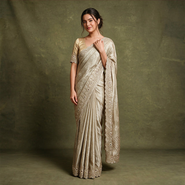Champagne viscose tissue Kanjivaram saree with scalloped beads and cutdana border and stitched blouse, worn