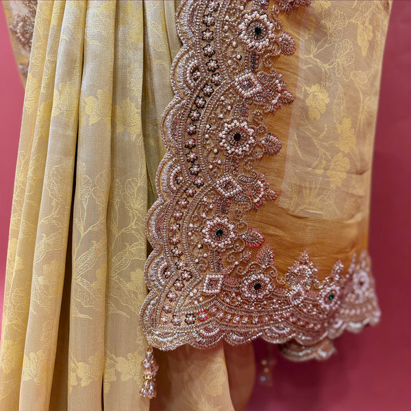 Close-up of rose-gold bead and cutdana flower border with dark stone centres and tassels on pale yellow silk