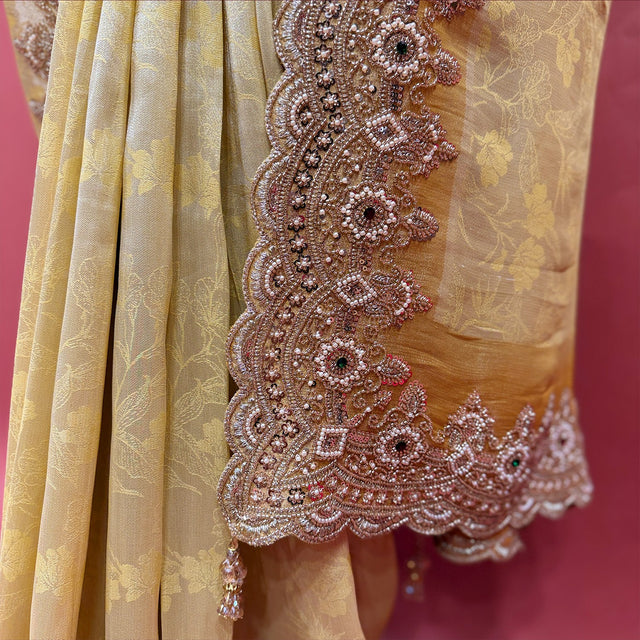 Close-up of rose-gold bead and cutdana flower border with dark stone centres and tassels on pale yellow silk