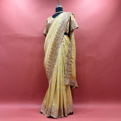 Pale yellow viscose silk saree with beaded handwork border and stitched blouse on mannequin