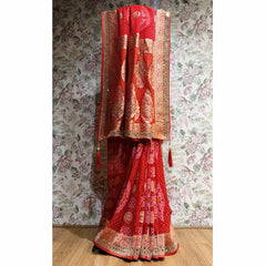 Red khaddi georgette saree with gold zari border and bandhani-style detailing