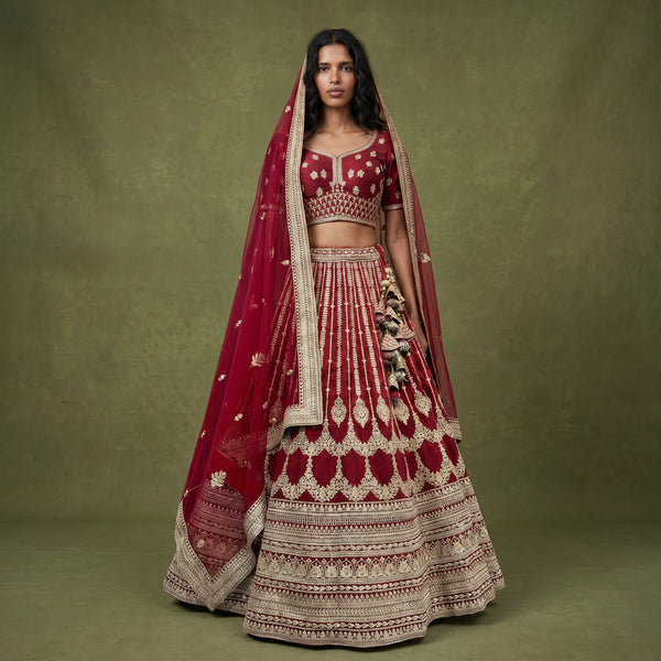 Maroon raw silk bridal lehenga with gold embroidery and matching dupatta