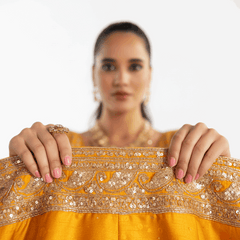 Close-up of mustard yellow lehenga waist with ornate silver sequin border