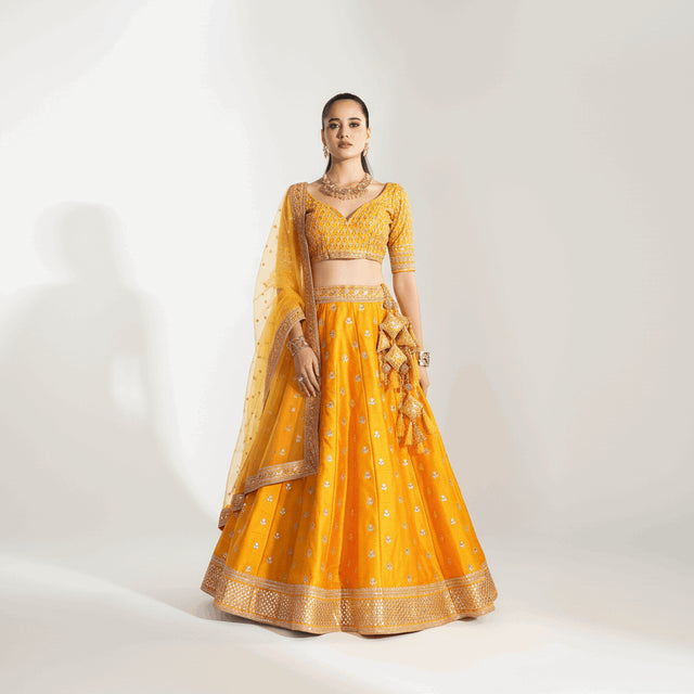 Butter yellow lehenga with gold-toned embroidery, matching blouse and dupatta