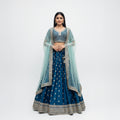 Designer lehenga with royal blue flared skirt, gold buti, and ornate border; aqua dupatta.