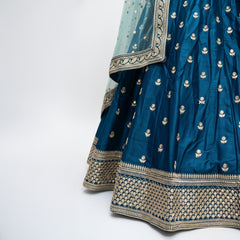 Royal blue lehenga skirt with gold buti pattern and wide embellished hem border.