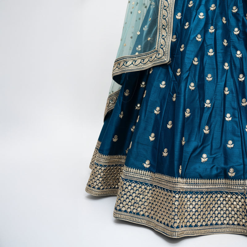 Royal blue lehenga skirt with gold buti pattern and wide embellished hem border.