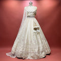 Ivory bridal lehenga with embroidered bodice, full skirt, and sheer lace dupatta