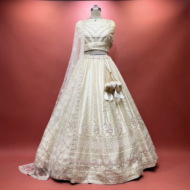 Ivory bridal lehenga with embroidered bodice, full skirt, and sheer lace dupatta