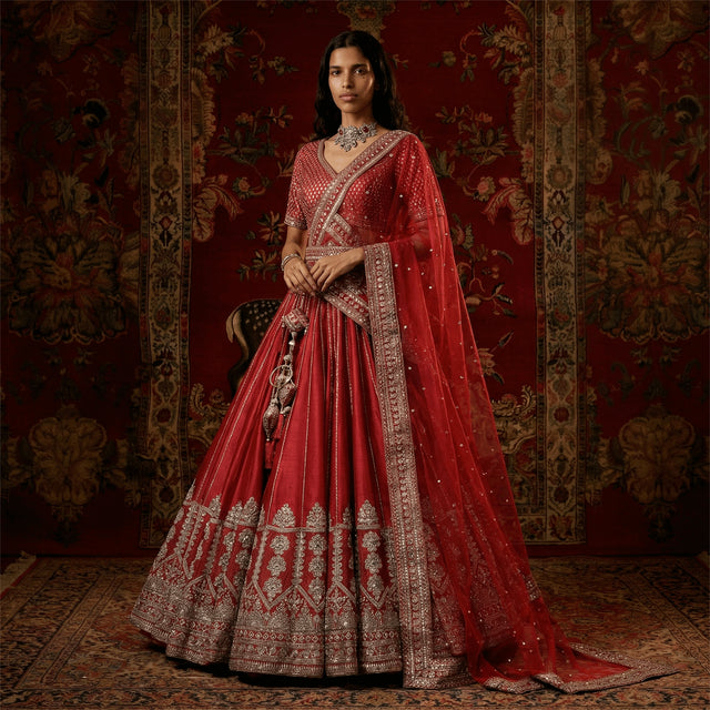 Red bridal lehenga with ornate silver border and draped dupatta