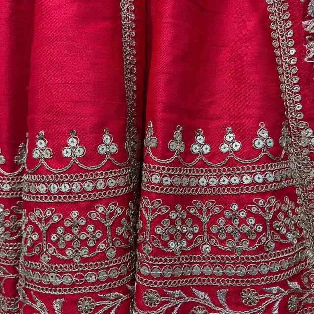 Red lehenga fabric with ornate silver mirror-work borders and embroidered bands