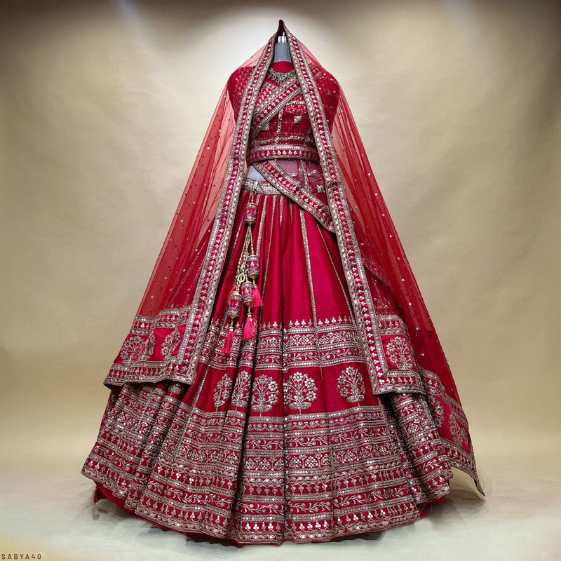 Red bridal lehenga set with wide embroidered hem and silver-gold border, full skirt