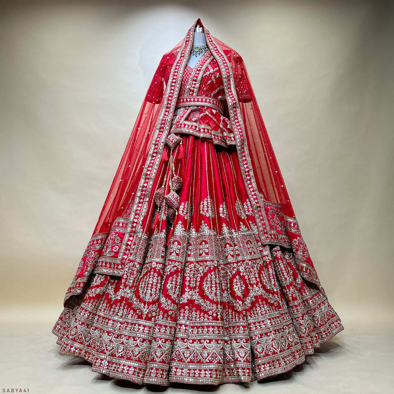 Red tiered bridal lehenga with silver embroidered bands and long veil