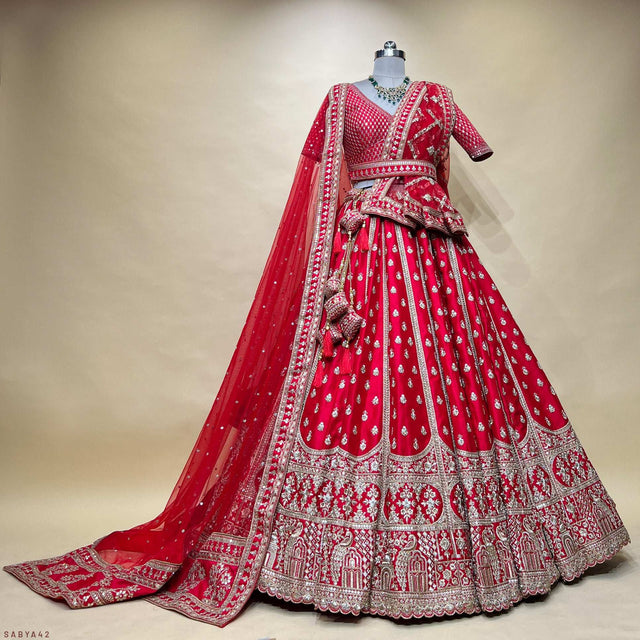 Royal red bridal lehenga on mannequin, with detailed silver border and flared skirt