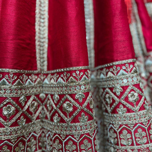 Close-up of red lehenga border with silver geometric mirror embroidery and beadwork