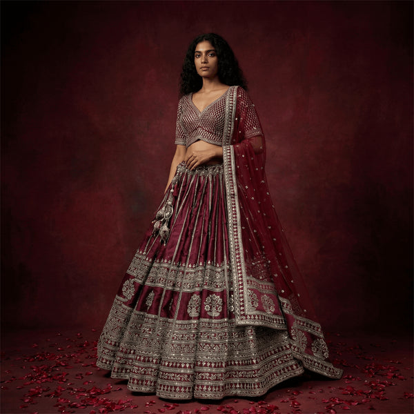 Maroon bridal lehenga skirt with ornate embroidered border, matching blouse and dupatta