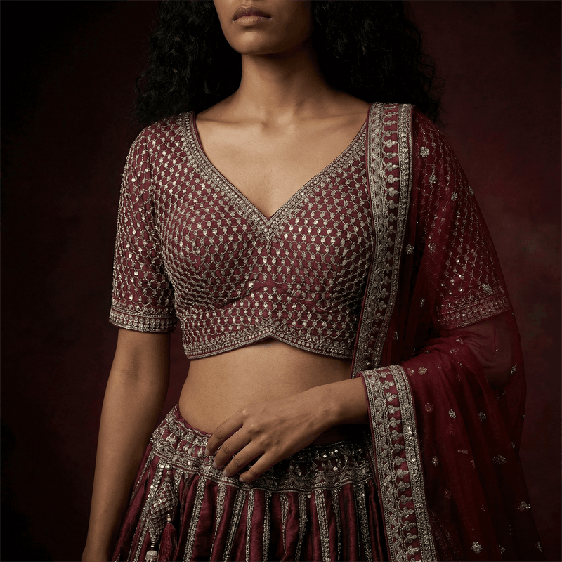 Maroon embroidered blouse with V neckline and silver trim; maroon skirt with silver borders