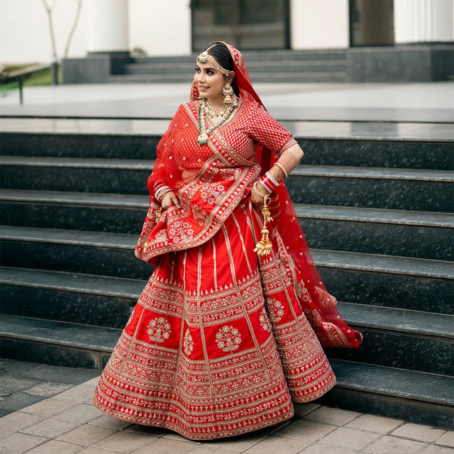 Red bridal lehenga with ornate silver borders, fitted blouse, draped dupatta