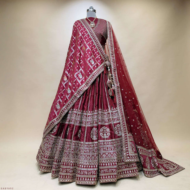 Maroon bridal lehenga set on mannequin, double dupatta draped over tiered skirt