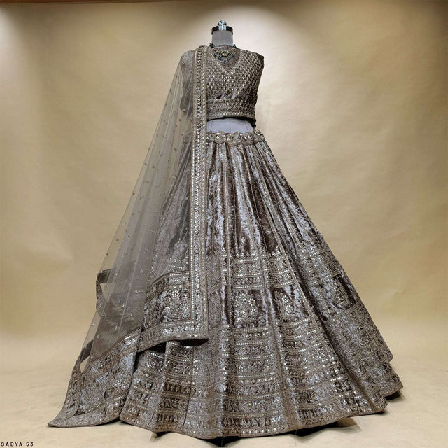 Embroidered velvet lehenga with sheer dupatta on mannequin, tiered sequin trim