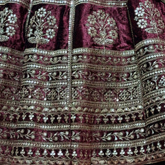 Maroon velvet lehenga skirt close-up with ornate zari bands and sequin motifs
