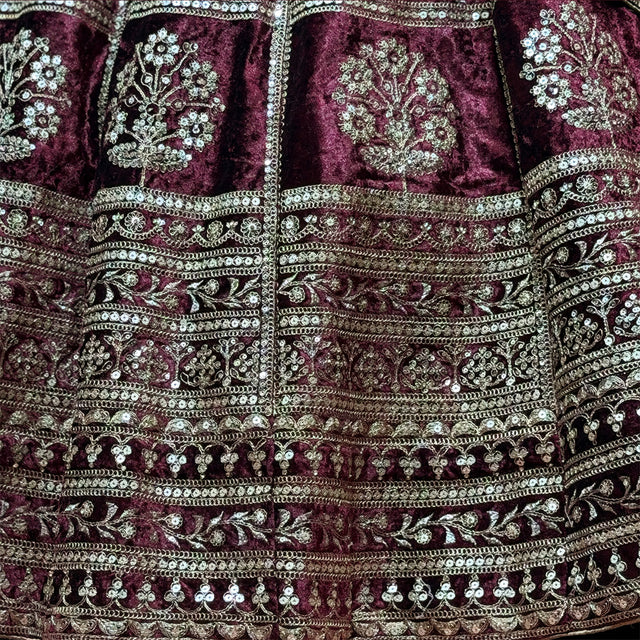 Maroon velvet lehenga skirt close-up with ornate zari bands and sequin motifs