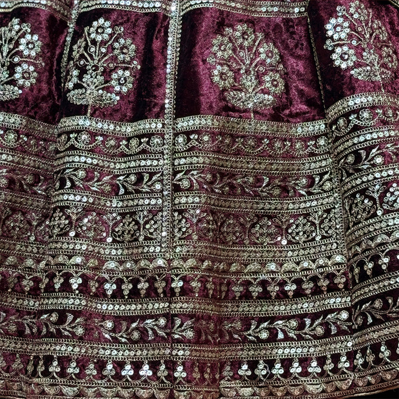 Maroon velvet lehenga skirt close-up with ornate zari bands and sequin motifs