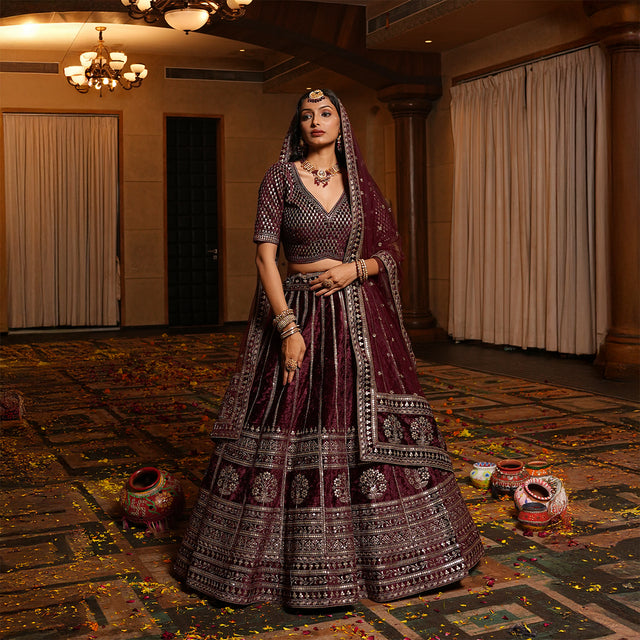 Maroon velvet lehenga with embroidered waistband and tiered skirt with silver borders