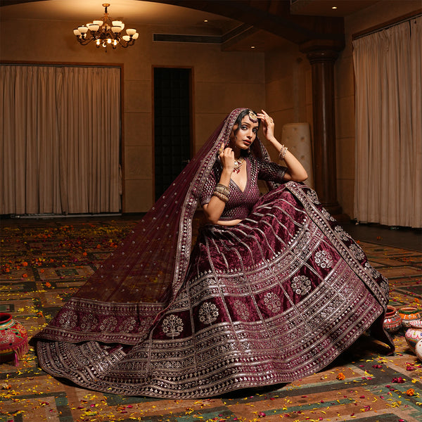 Maroon velvet lehenga with flared skirt and ornate silver border, plus draped dupatta