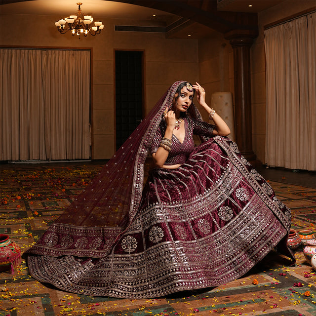 Maroon velvet lehenga with flared skirt and ornate silver border, plus draped dupatta