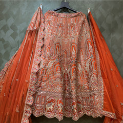 Rust-orange bridal lehenga with dense ornate embroidery and flared skirt, full-length dupatta