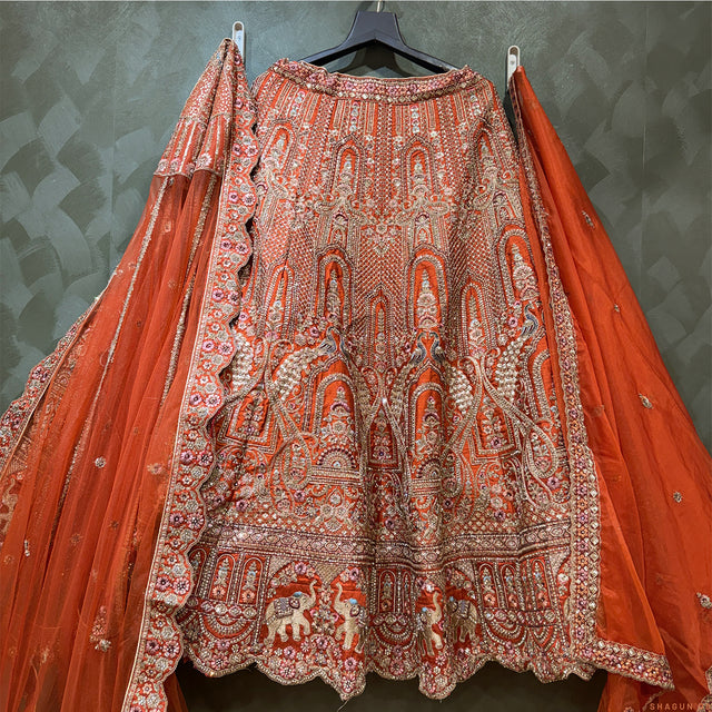 Rust-orange bridal lehenga with dense ornate embroidery and flared skirt, full-length dupatta