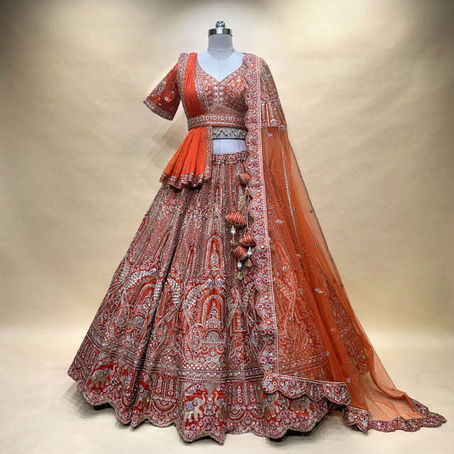 Rust-orange embroidered bridal lehenga with silver motifs, tiered skirt and matching dupatta